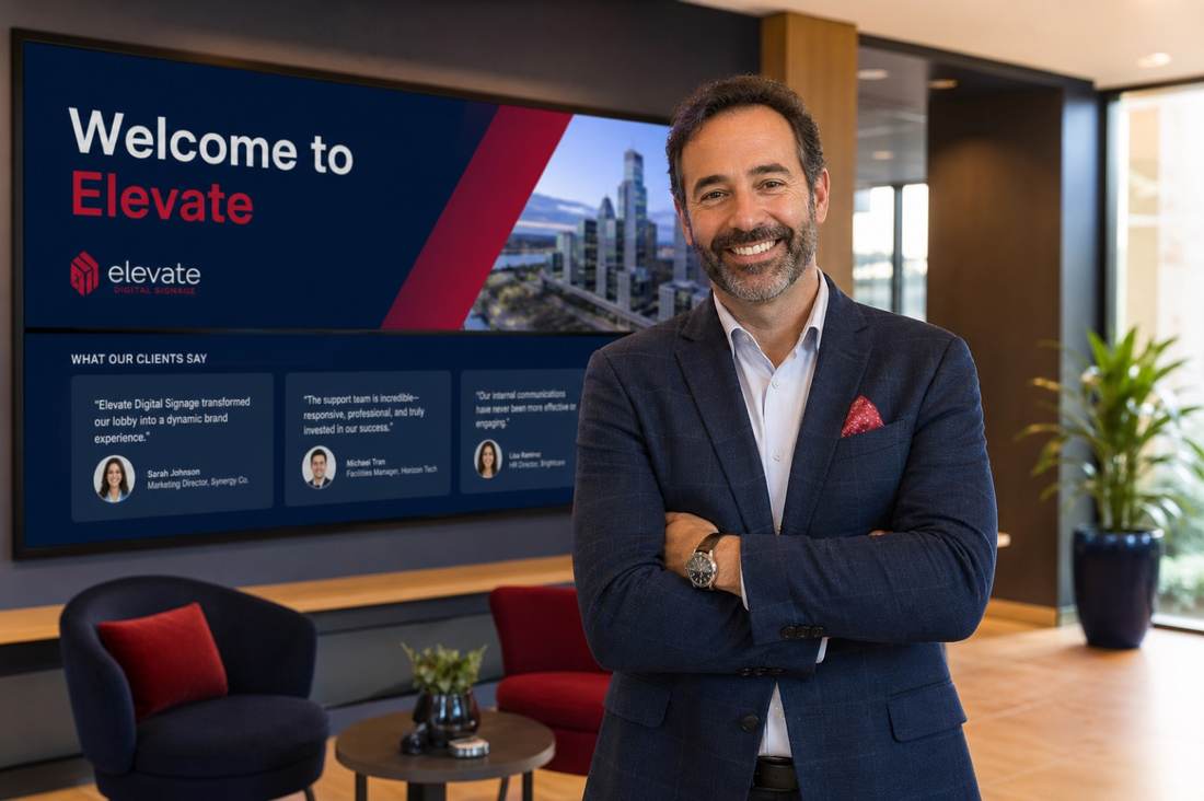 Business leader in a lobby with digital welcome screens
